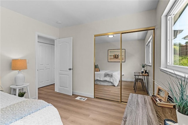 bedroom with a closet and light hardwood / wood-style flooring