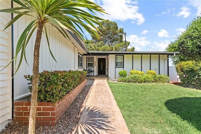 doorway to property featuring a yard