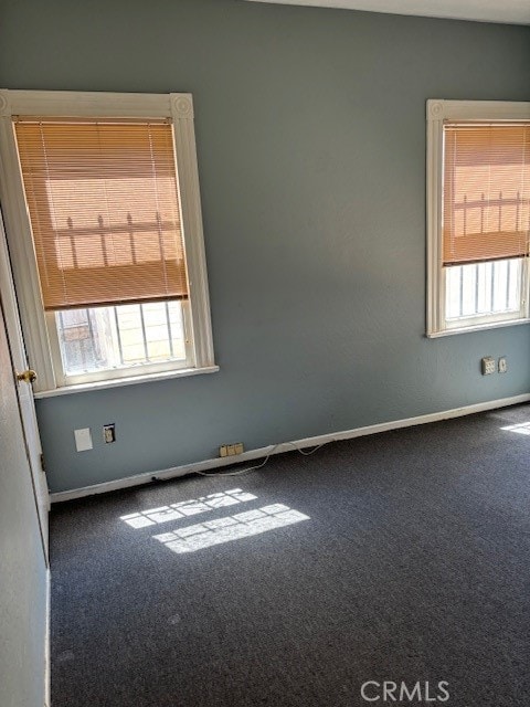 carpeted empty room with a healthy amount of sunlight