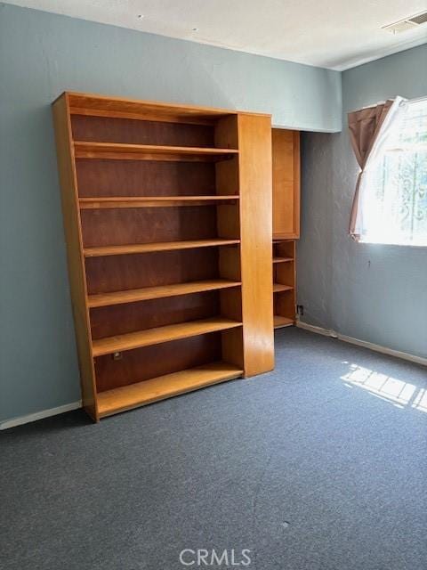 unfurnished bedroom featuring dark colored carpet