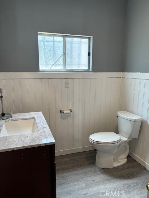 bathroom featuring wood-type flooring, vanity, and toilet