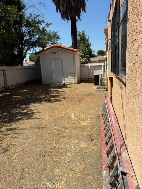 view of yard with cooling unit and a storage shed