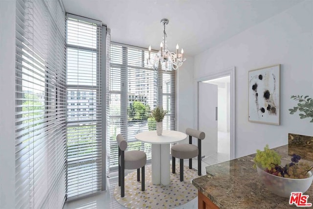 dining space featuring an inviting chandelier, light tile patterned flooring, and a healthy amount of sunlight