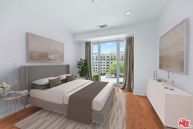 bedroom featuring light hardwood / wood-style floors and access to exterior