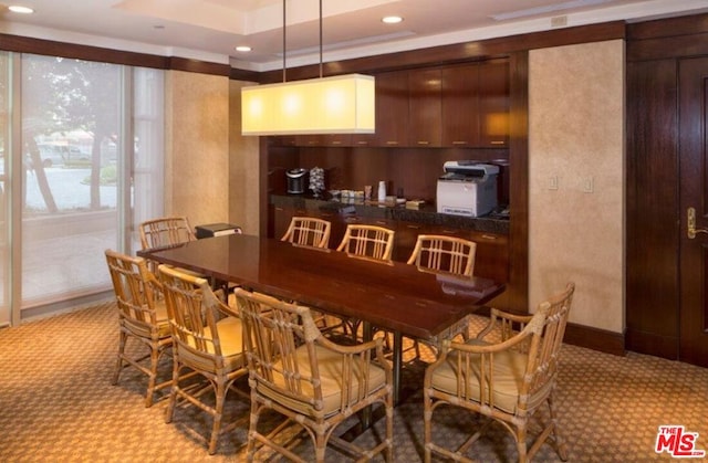 bar featuring light carpet, dark brown cabinetry, and pendant lighting