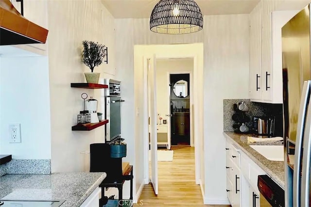 kitchen with backsplash, sink, light stone countertops, stainless steel appliances, and white cabinets