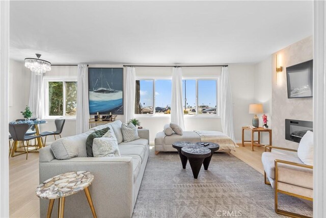 living room with a notable chandelier and light hardwood / wood-style flooring