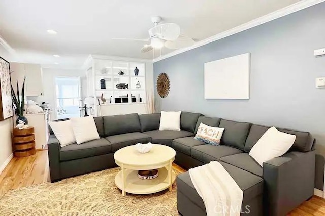 living room with ceiling fan, ornamental molding, and light hardwood / wood-style floors