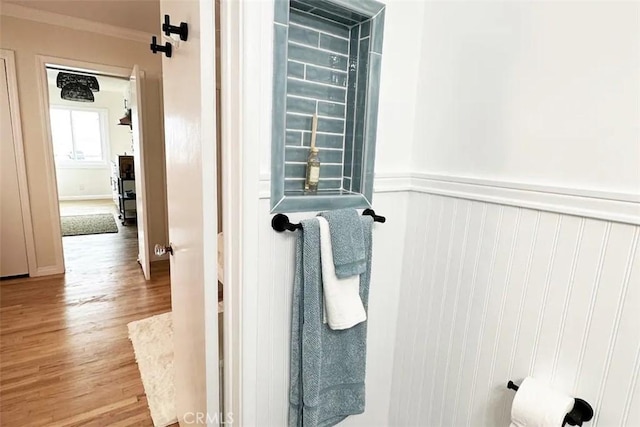 bathroom with wood-type flooring and ornamental molding