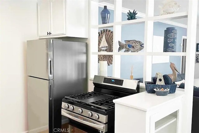 kitchen with white cabinetry, appliances with stainless steel finishes, and ornamental molding