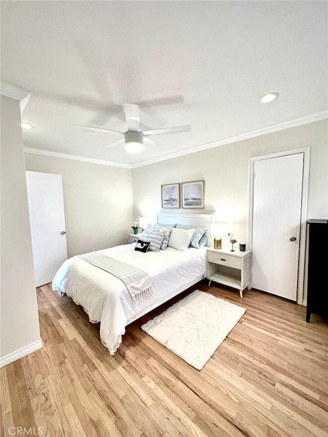 bedroom featuring ceiling fan, light wood-type flooring, and crown molding