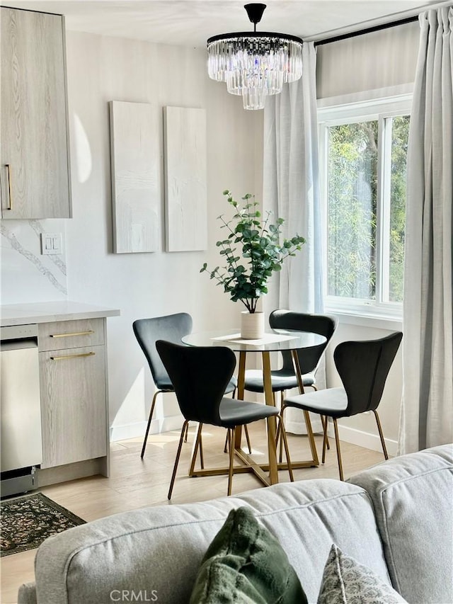 dining area featuring light wood-type flooring and an inviting chandelier