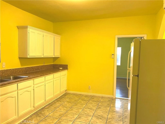 kitchen featuring white cabinets, white fridge, and sink