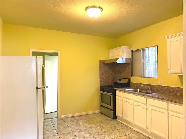 kitchen with sink, a textured ceiling, stainless steel range with gas stovetop, white cabinetry, and white refrigerator