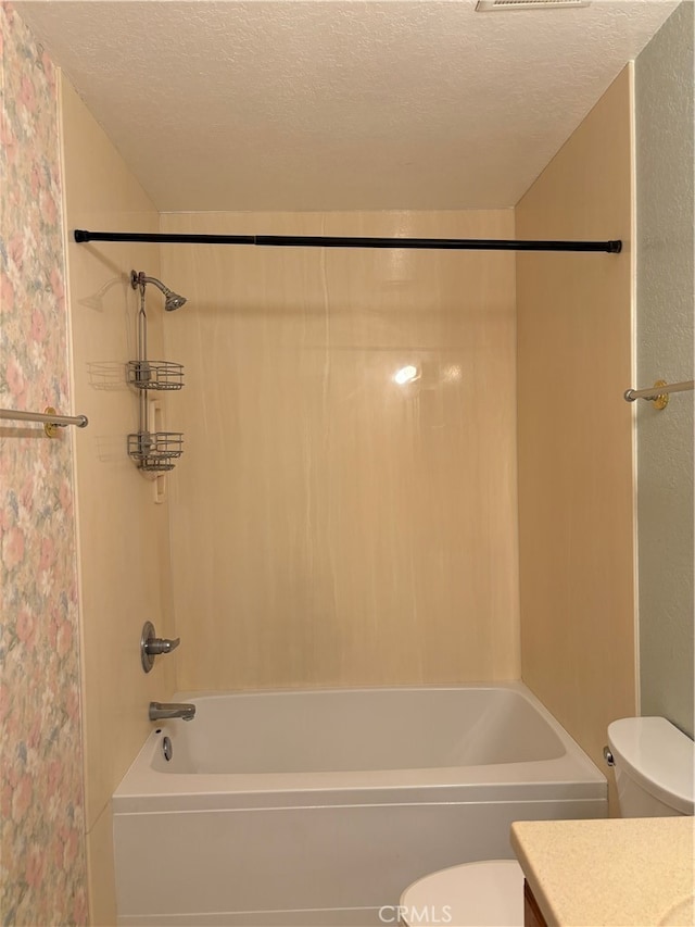 full bathroom featuring toilet, vanity, shower / bathing tub combination, and a textured ceiling