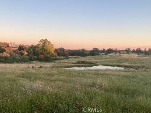 nature at dusk featuring a rural view and a water view