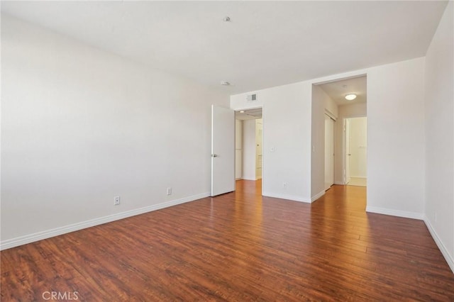 spare room featuring dark wood-type flooring