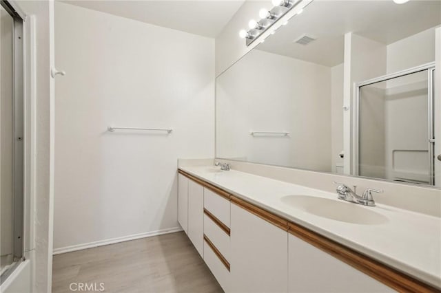 bathroom with vanity, hardwood / wood-style floors, and walk in shower