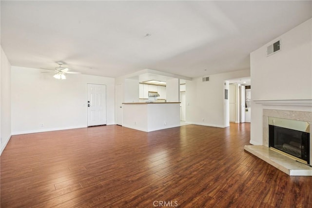 unfurnished living room featuring dark hardwood / wood-style flooring, ceiling fan, and a high end fireplace