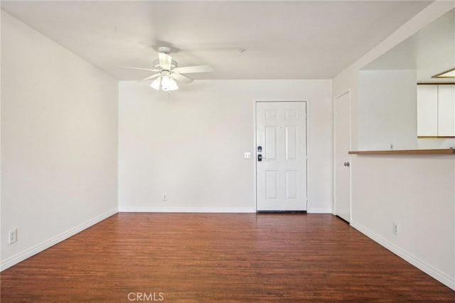 spare room with dark wood-type flooring and ceiling fan