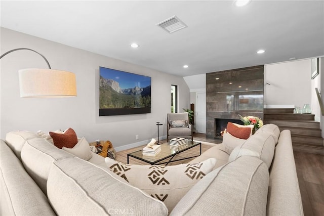 living room featuring a tiled fireplace and hardwood / wood-style floors