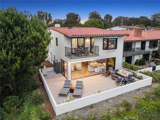 rear view of house with an outdoor living space and a patio