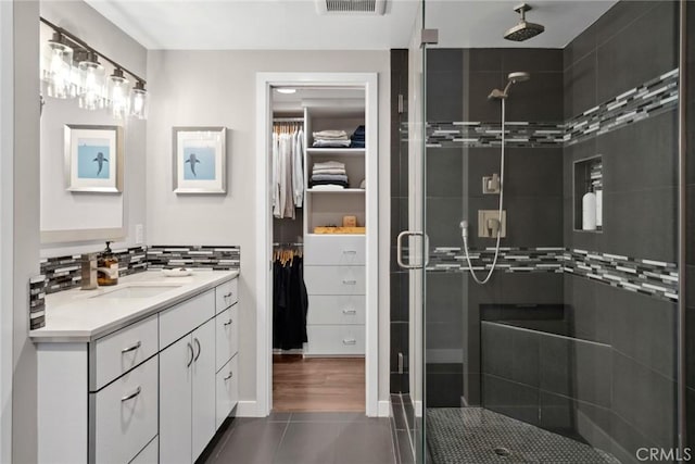 bathroom featuring vanity, tile patterned floors, and a shower with shower door