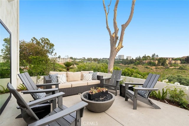 view of patio with an outdoor living space with a fire pit