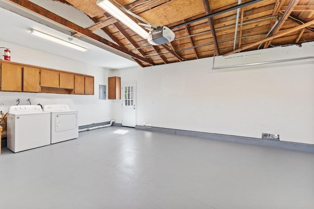 garage with a garage door opener, electric panel, and washer and dryer