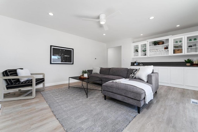 living room with ceiling fan and light wood-type flooring