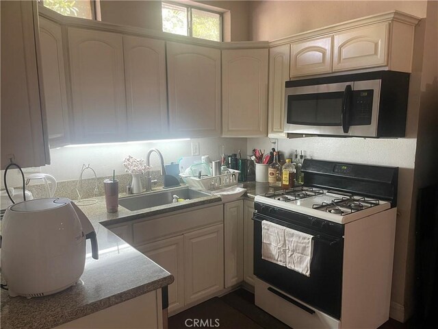 kitchen with white range with gas cooktop and sink