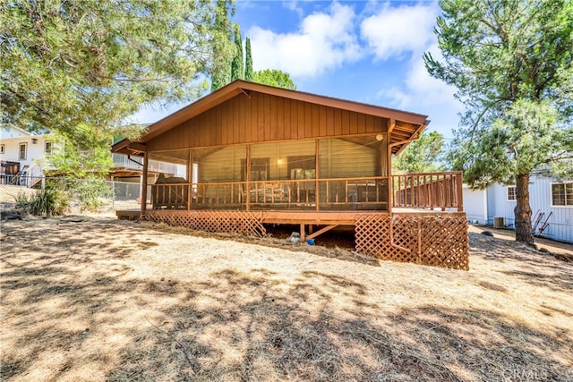 rear view of property with a wooden deck and a sunroom