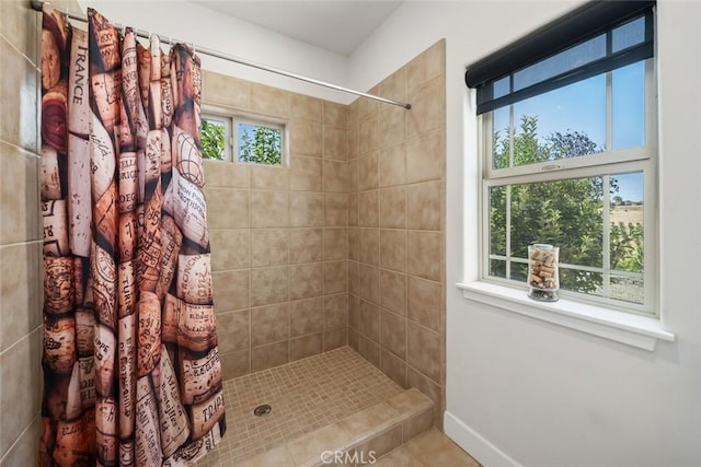 bathroom featuring baseboards and a tile shower