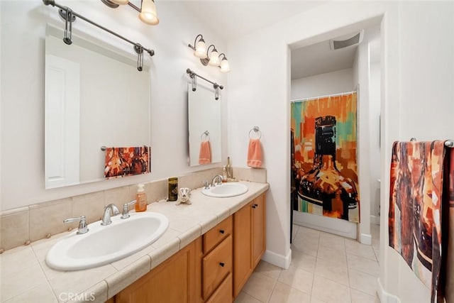 bathroom with double vanity, visible vents, a sink, and tile patterned floors