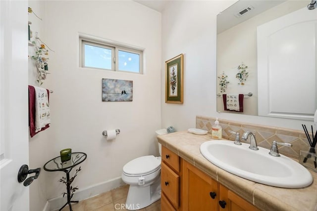 half bathroom featuring tile patterned flooring, toilet, vanity, visible vents, and backsplash