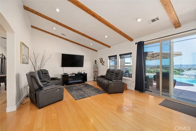 living room with vaulted ceiling with beams, plenty of natural light, visible vents, and wood finished floors