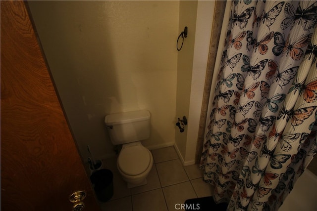 bathroom featuring shower / tub combo, tile patterned flooring, and toilet