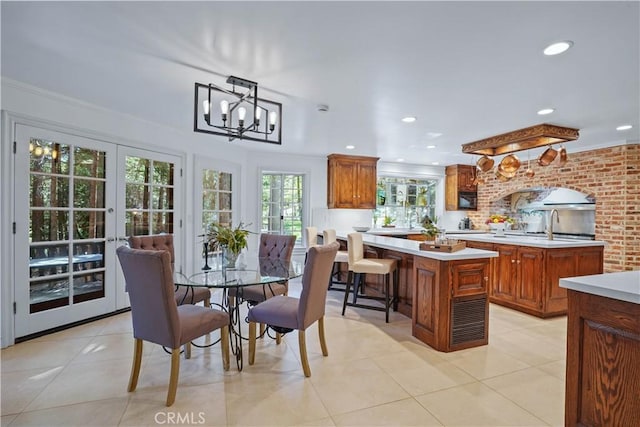 tiled dining room featuring a notable chandelier and ornamental molding