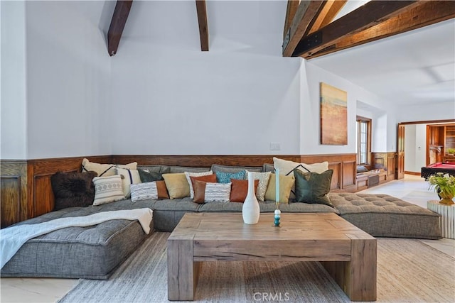 living room with beam ceiling and wood walls