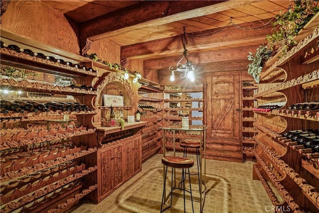 wine cellar with beam ceiling, wood ceiling, log walls, and a chandelier