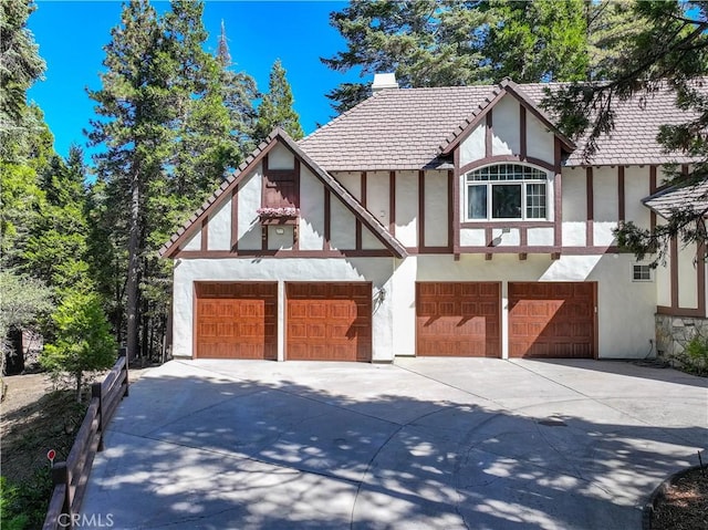 english style home featuring a garage