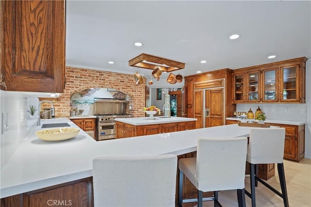 kitchen featuring sink, a center island, brick wall, a kitchen bar, and high end appliances