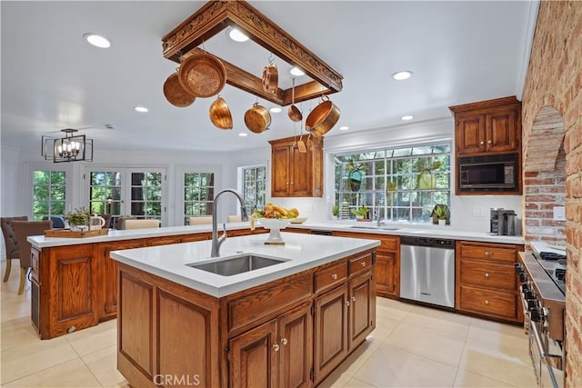 kitchen with sink, a kitchen island with sink, appliances with stainless steel finishes, and a chandelier