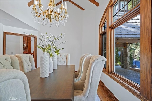 dining space with hardwood / wood-style flooring, ceiling fan with notable chandelier, and lofted ceiling