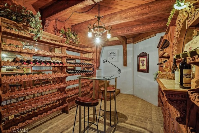 wine room with beam ceiling, wooden ceiling, and a notable chandelier