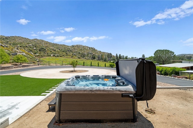 exterior space featuring a jacuzzi and a mountain view