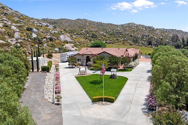 surrounding community with a lawn and a mountain view