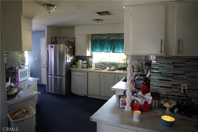 kitchen featuring backsplash, white appliances, and white cabinets