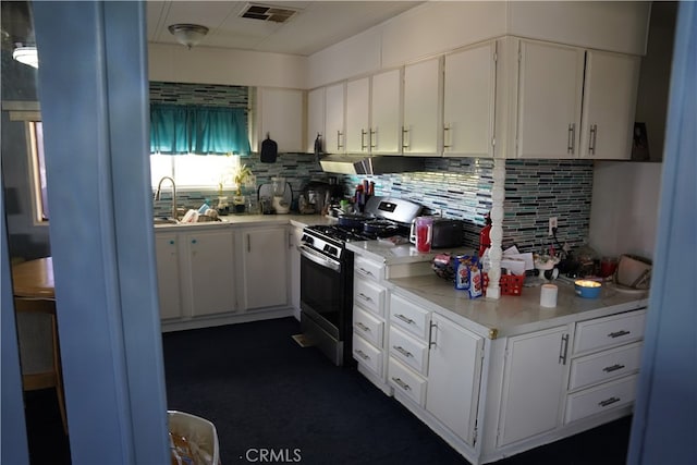 kitchen featuring white cabinets, gas range, sink, and extractor fan