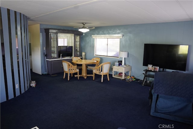 carpeted dining space with ceiling fan